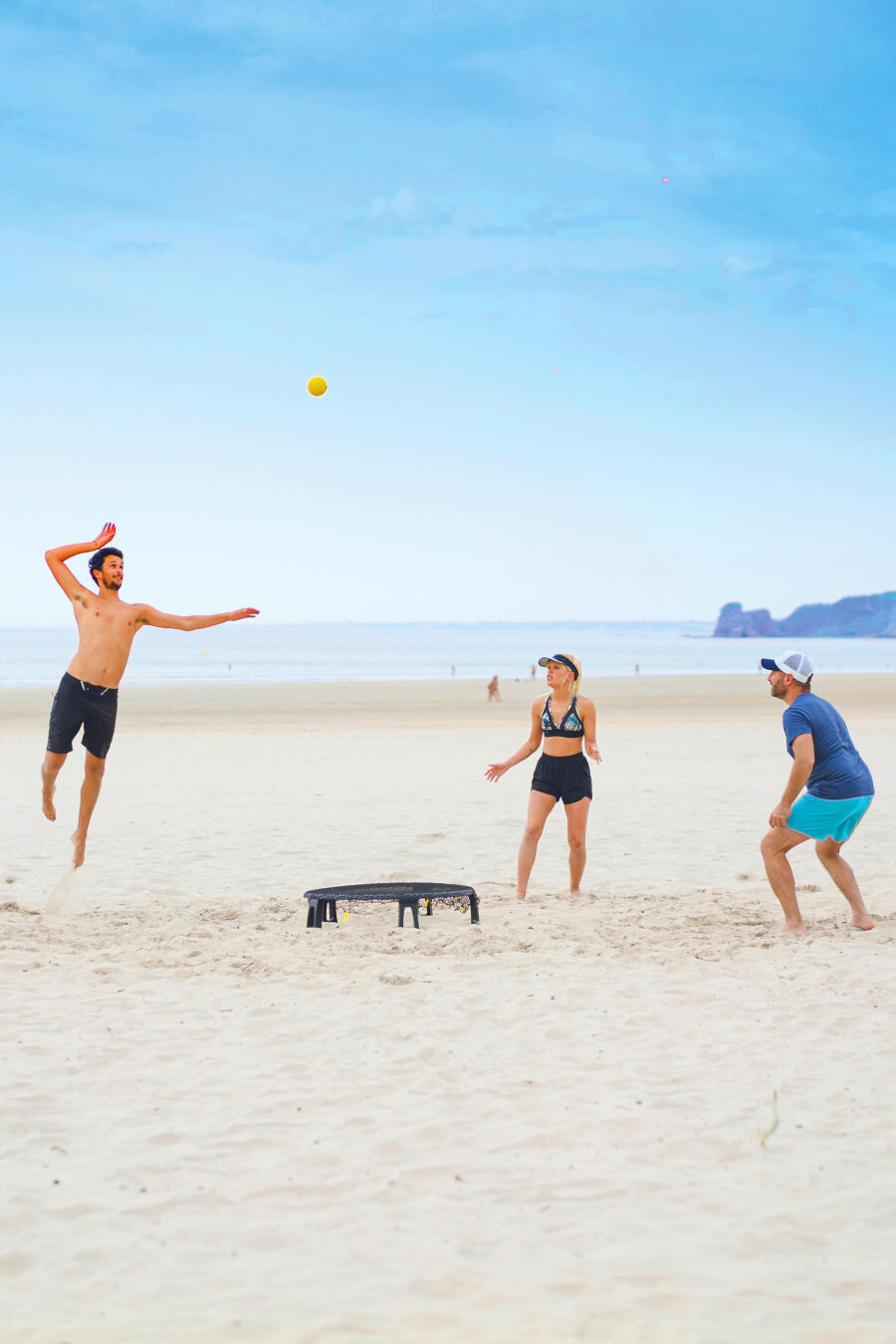 grupo de pessoas a jogar spikeball na praia