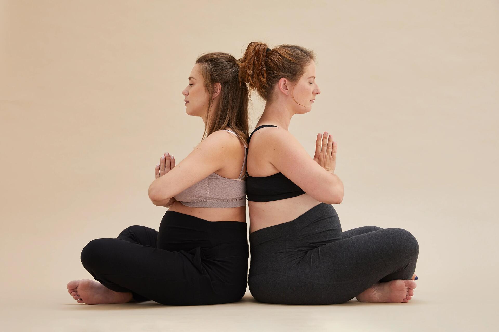 kobiety w ciąży w legginsach medytujące podczas trenowania jogi prenatalnej
