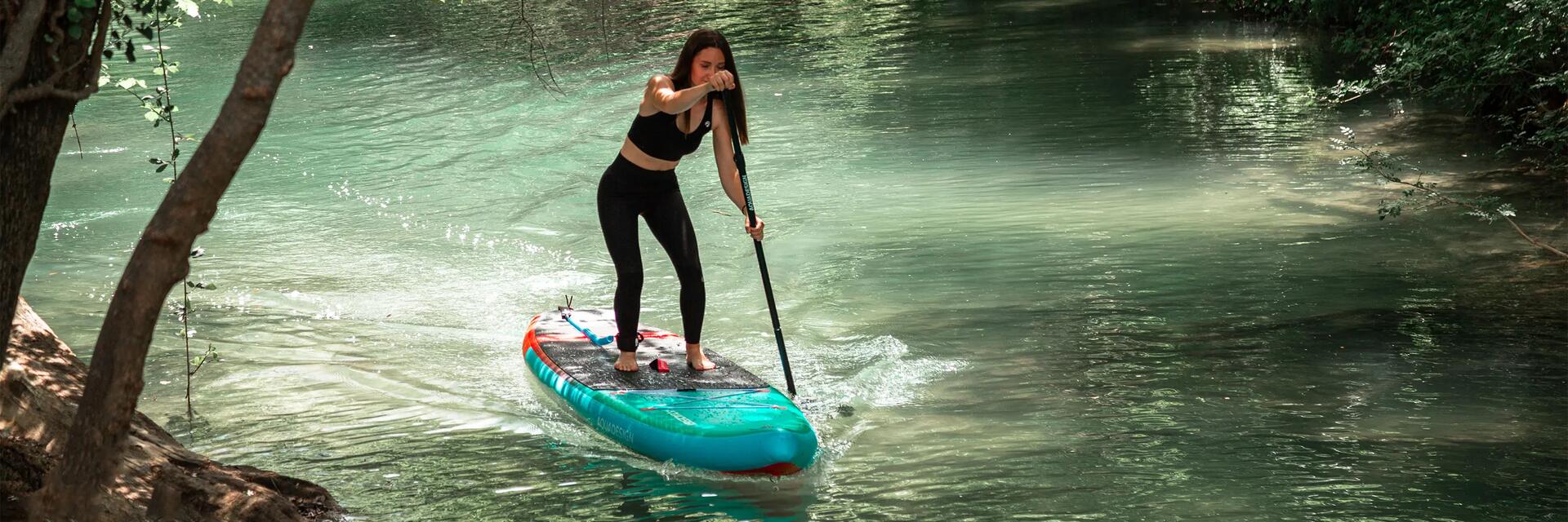 Frau nutzt ein SUP-Paddel auf einem Board