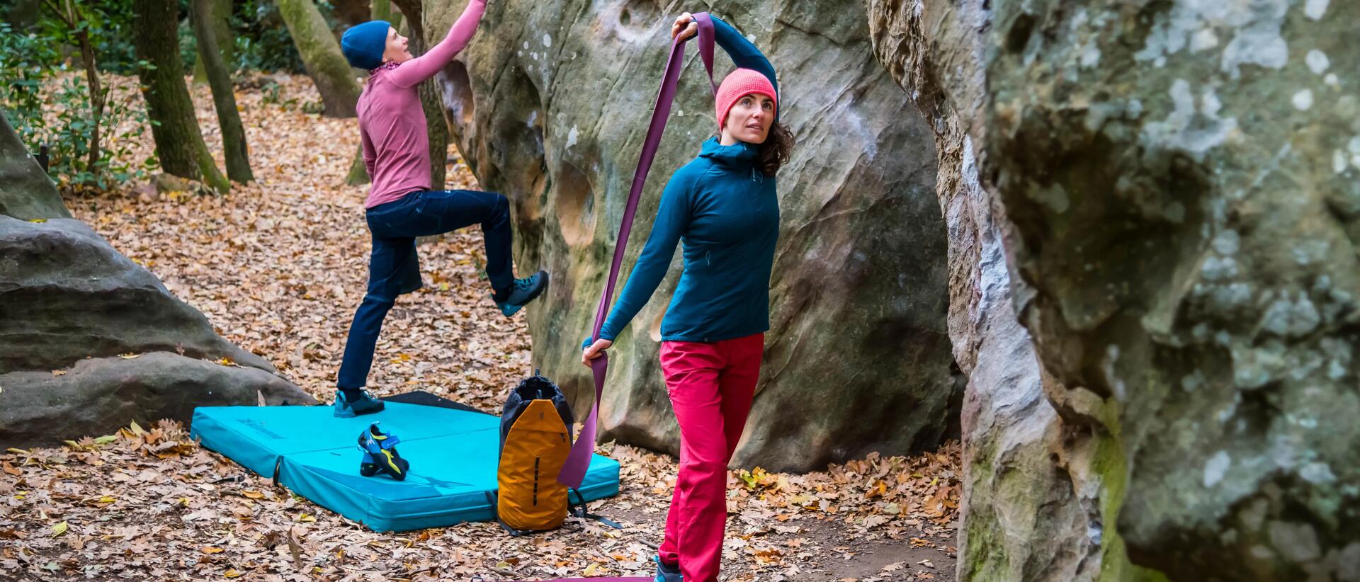 kobiety stojące obok skały w strojach do wspinaczki z akcesoriami do boulderingu