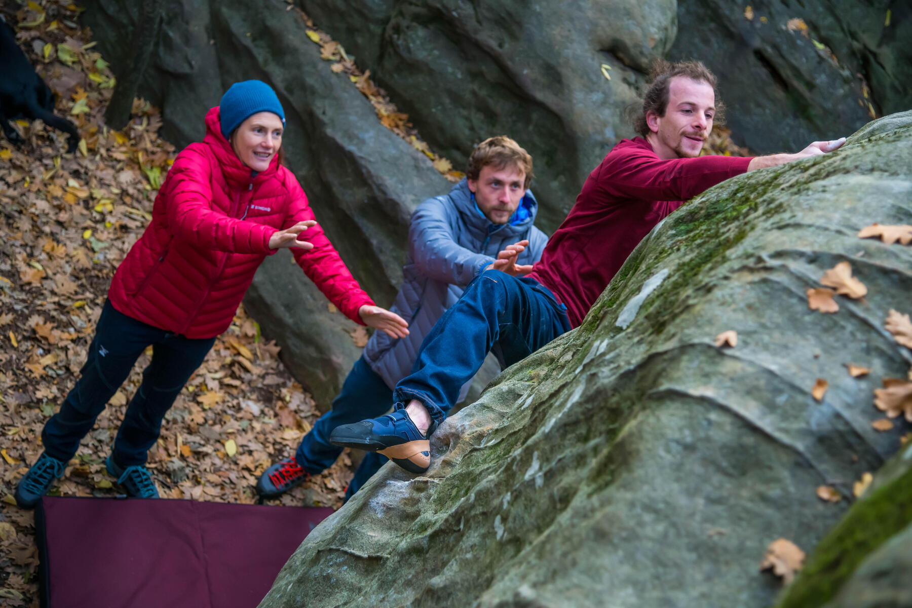 Drei Personen haben Freude am Bouldern. 