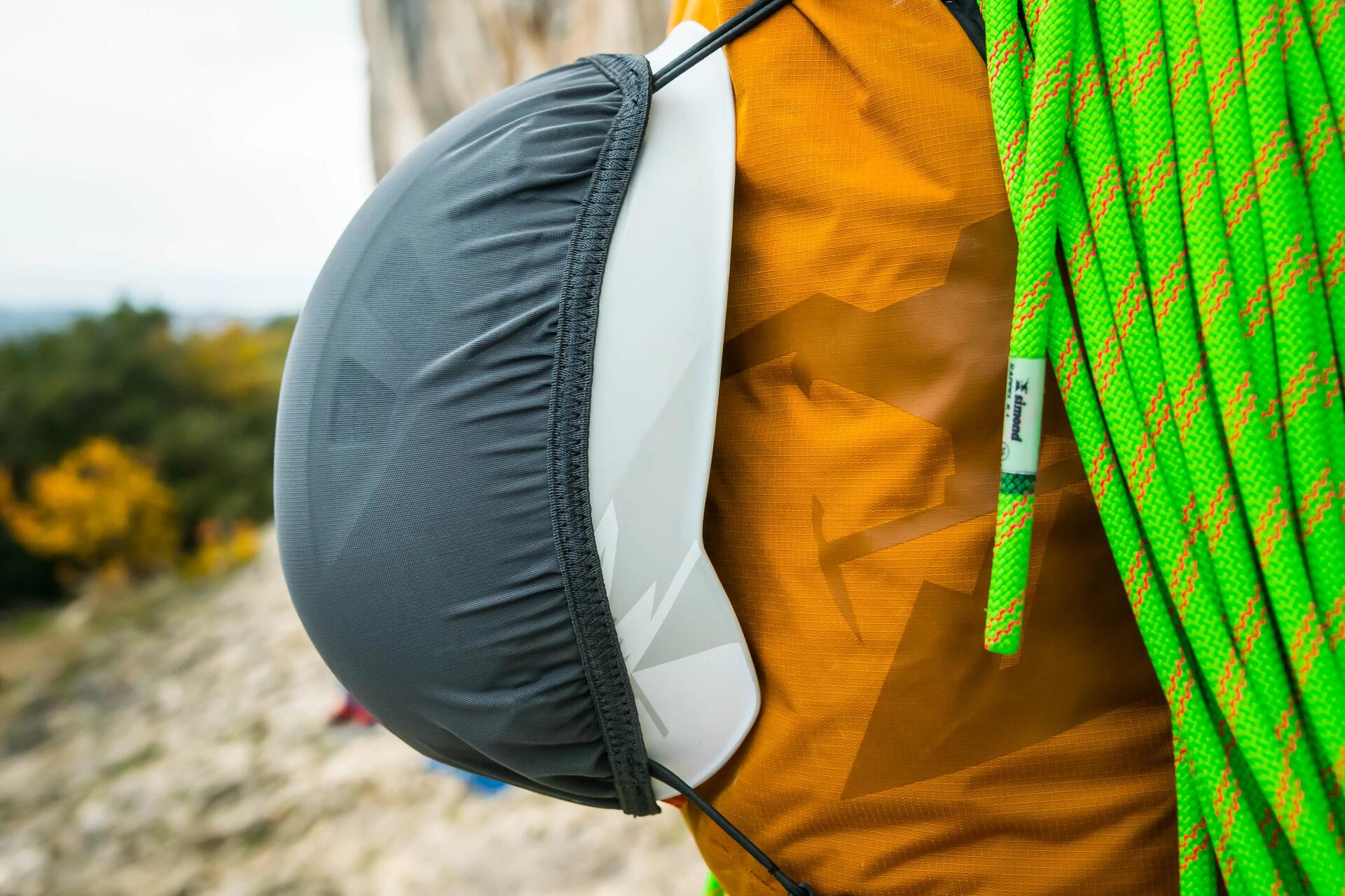 A close-up of a green climbing rope and helmet backpack