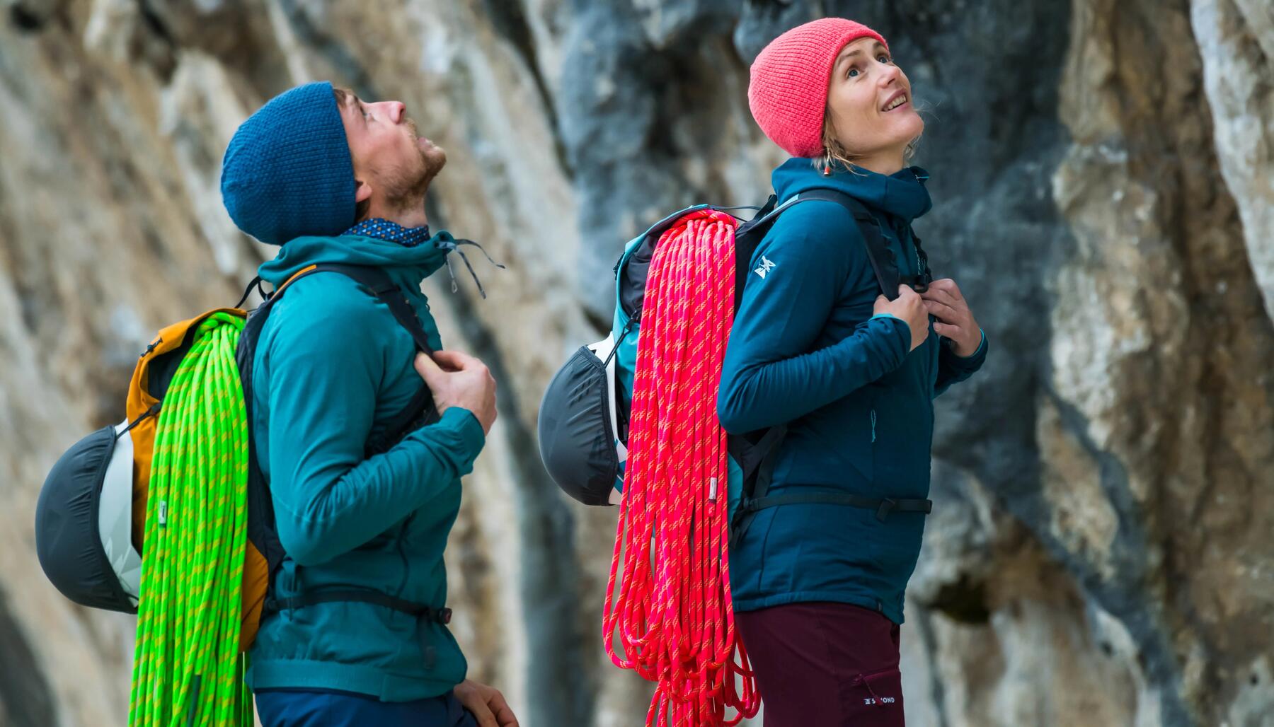 man and woman carrying climbing ropes on backpacks