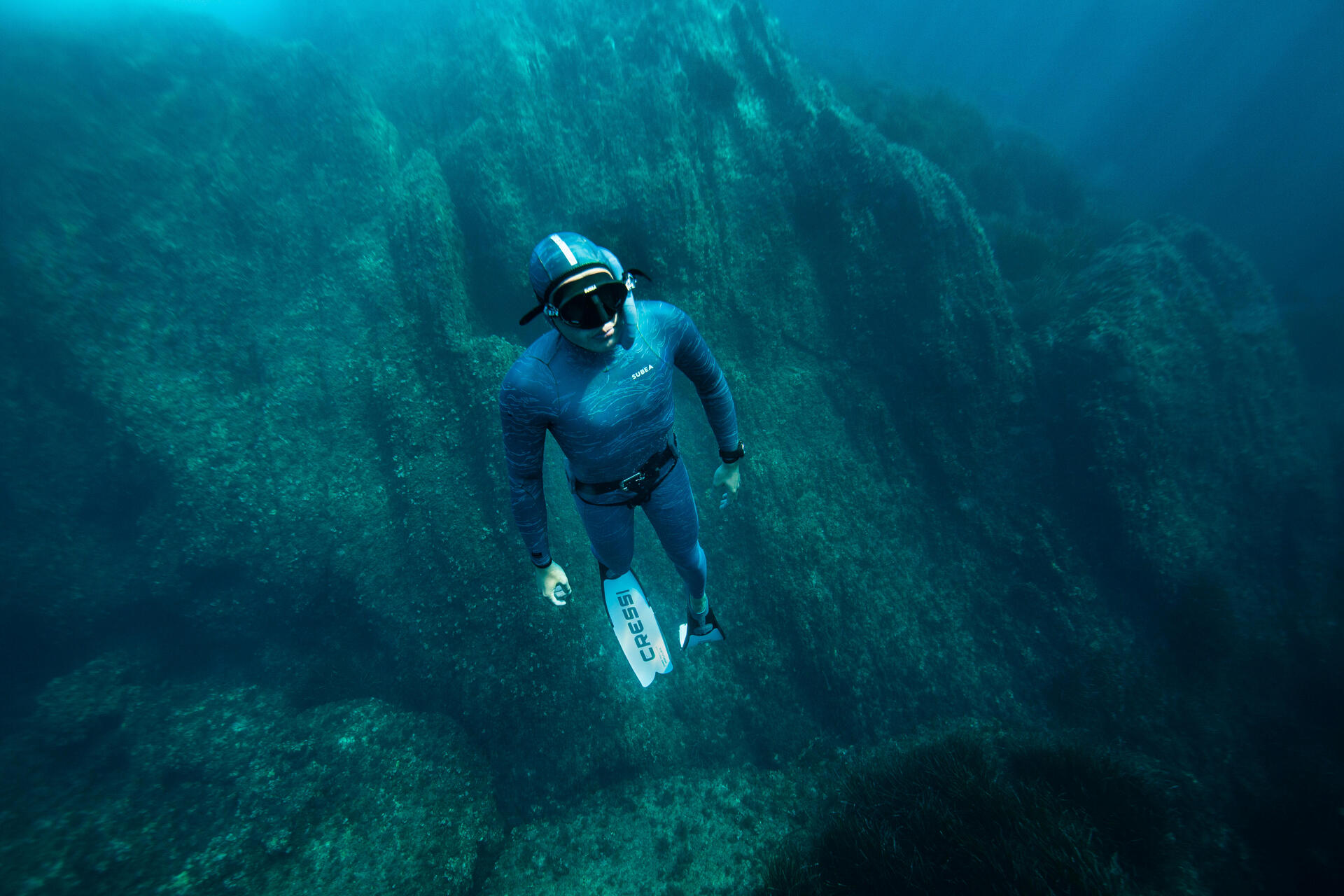 mężczyzna nurkujący w stroju i płetwach do freedivingu