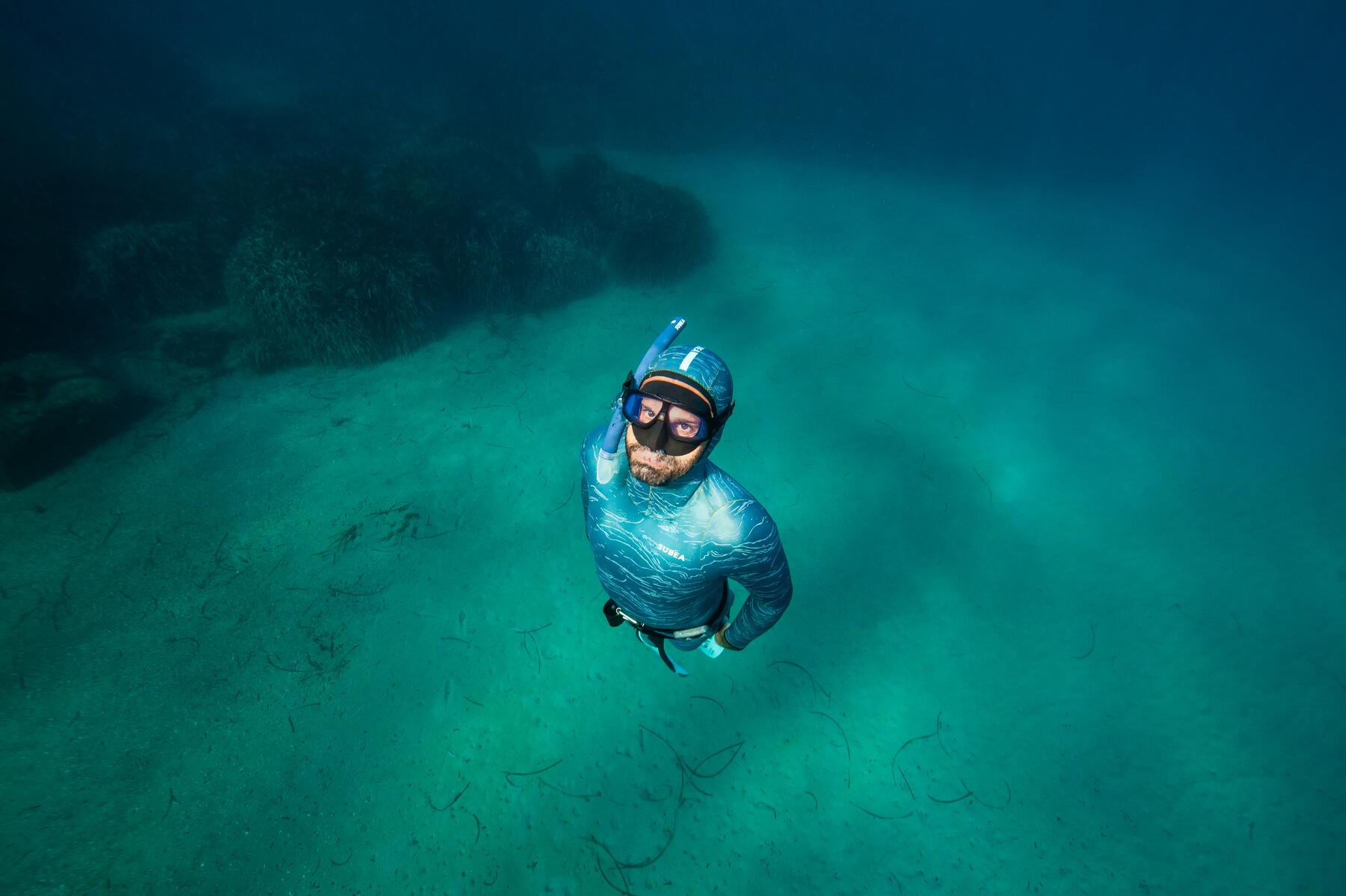 Mężczyzna uprawiający freediving nurkujący pod wodą z fajką czołową do pływania