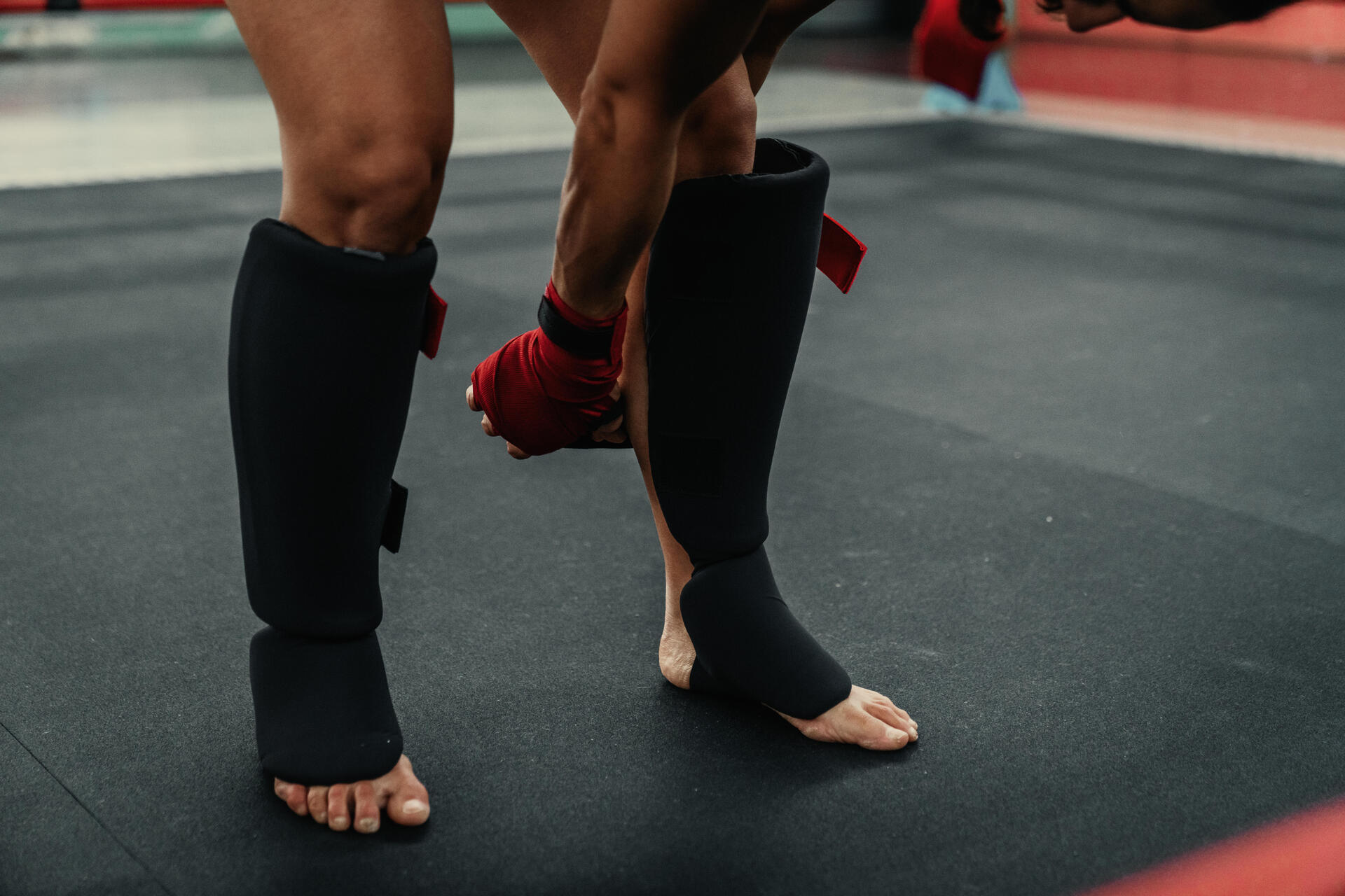 Osoba ściągająca ochraniacze na piszczele po skończonym treningu mma