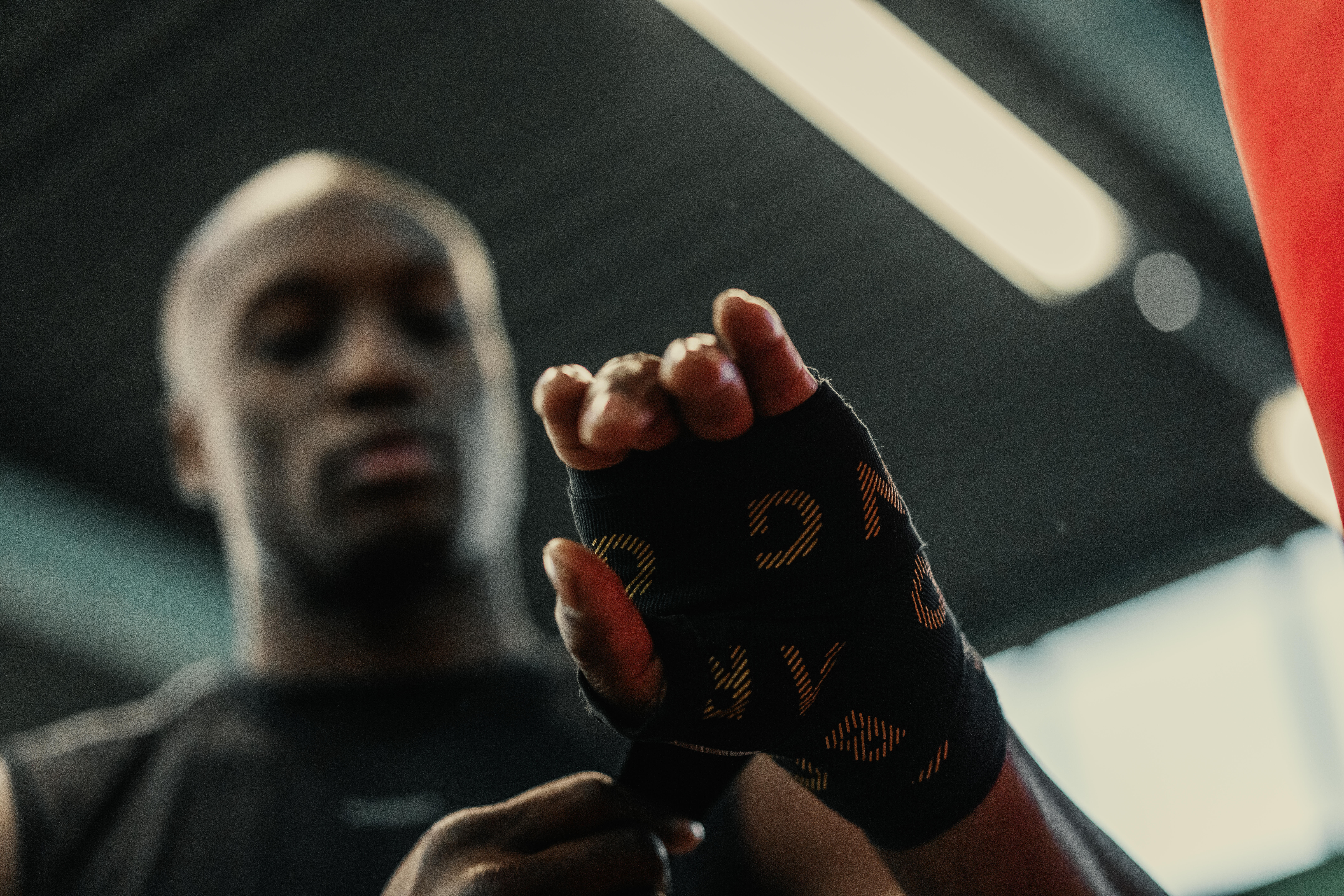 Boxer wrapping a hand with black boxing hand wraps before training