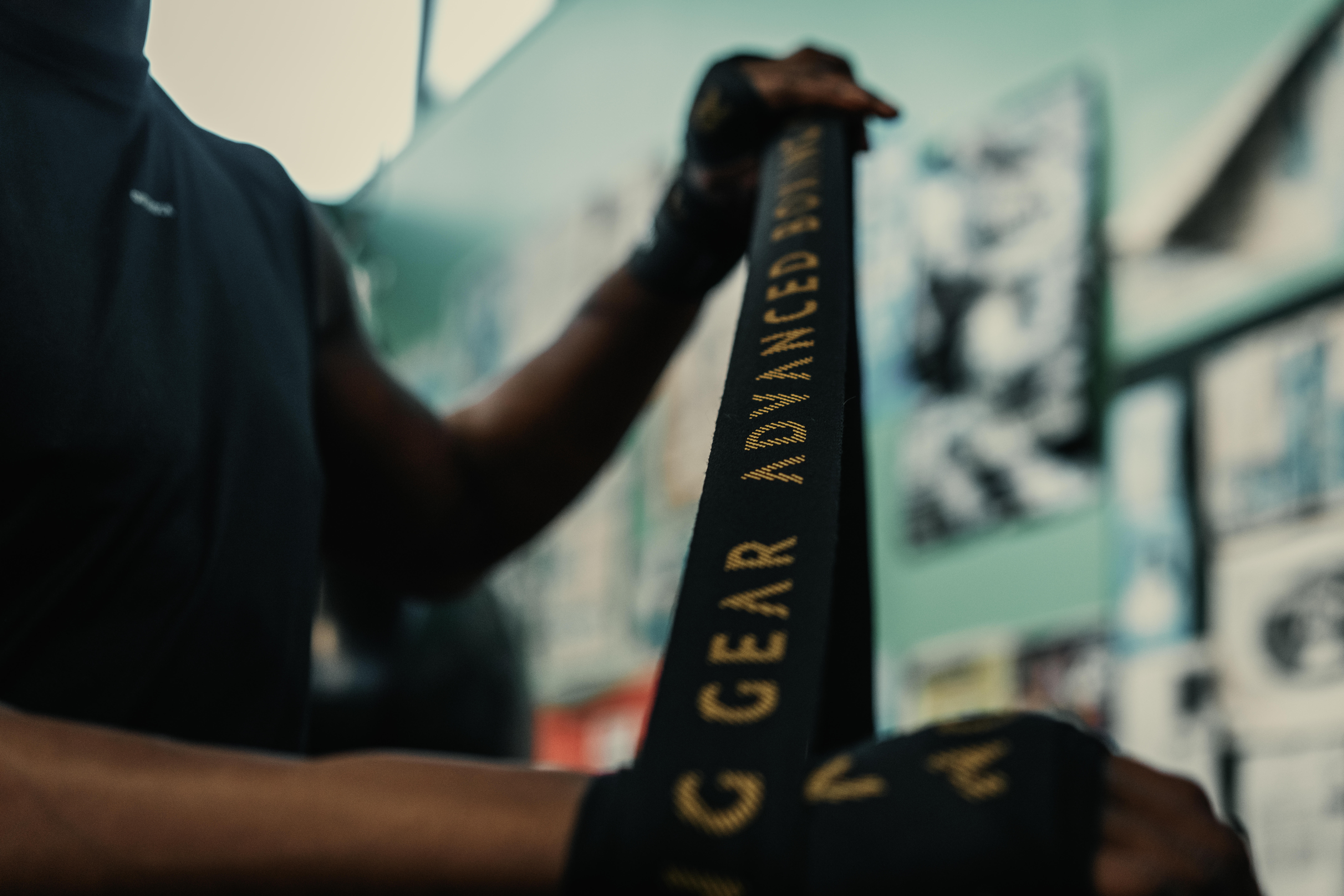 Boxer wrapping their hands with black boxing hand wraps before training