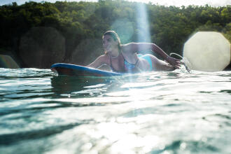 femme nageant avec une planche de surf