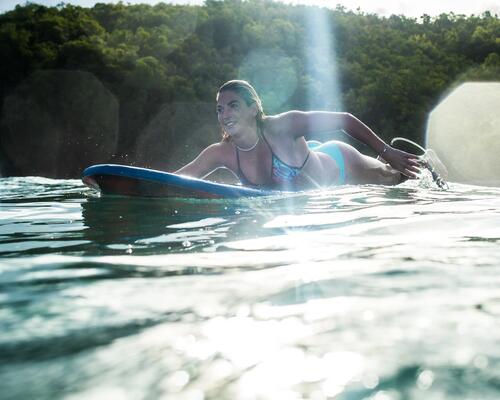 femme nageant avec une planche de surf