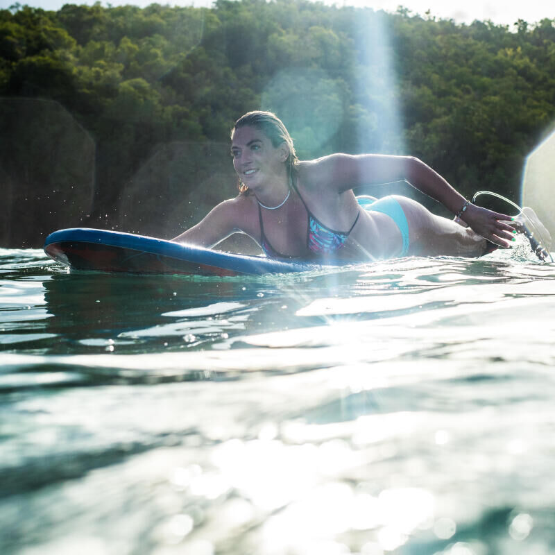 femme nageant avec une planche de surf
