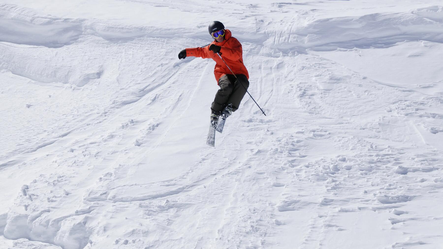 Man die een truc doet op zijn ski's