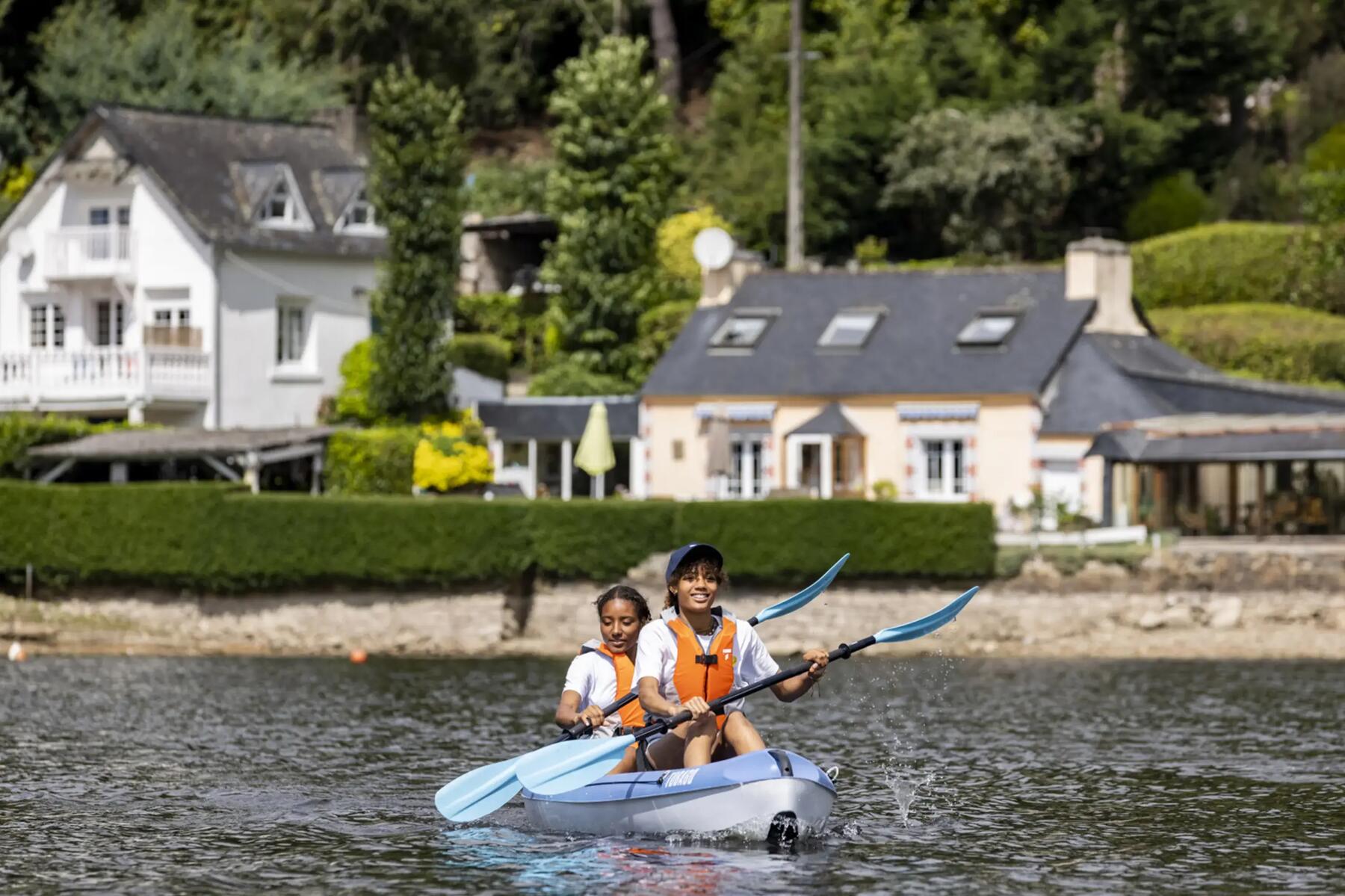 Zwei Frauen fahren auf einem Fluss Kajak