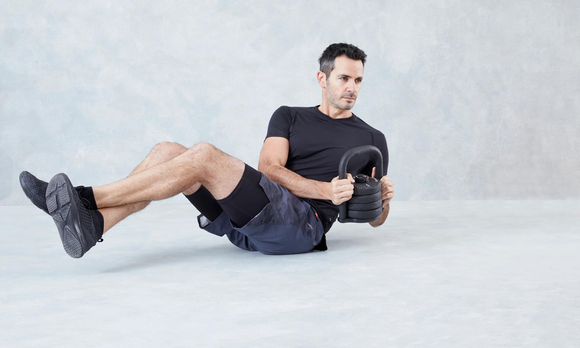 mężczyzna w odzieży i butach fitness trenujący z kettlebell