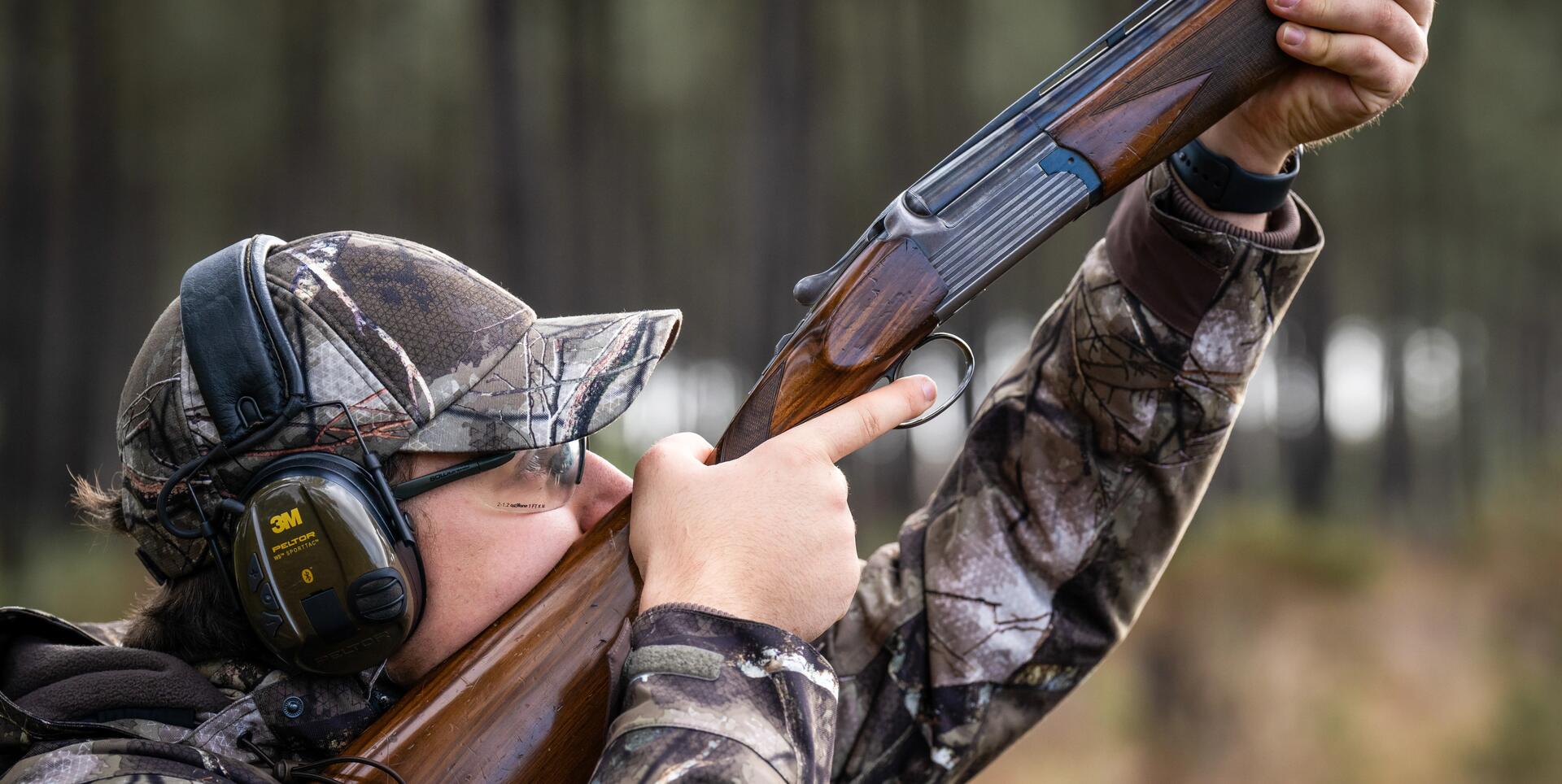 Un chasseur de pigeon ramier avec un casque anti-bruit électronique Peltor