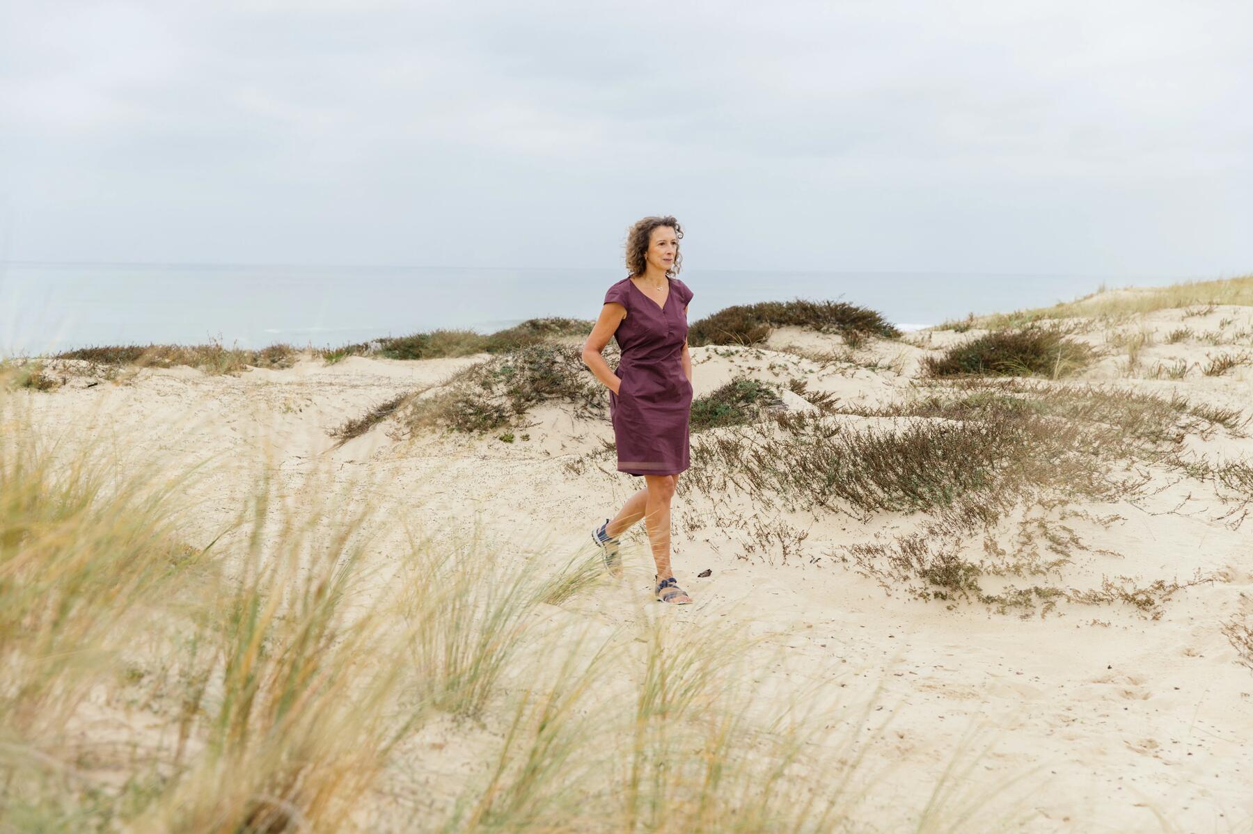 mujer con vestido andando por la playa