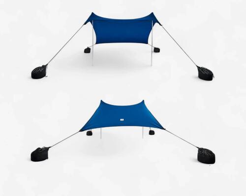 Gezin zit onder de tarp op het strand