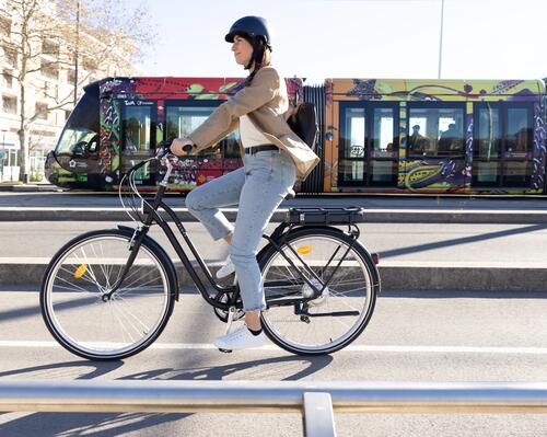 kobieta jadąca na rowerze elektrycznym w mieście zgodnie z przepisami kodeksu ruchu drogowego 