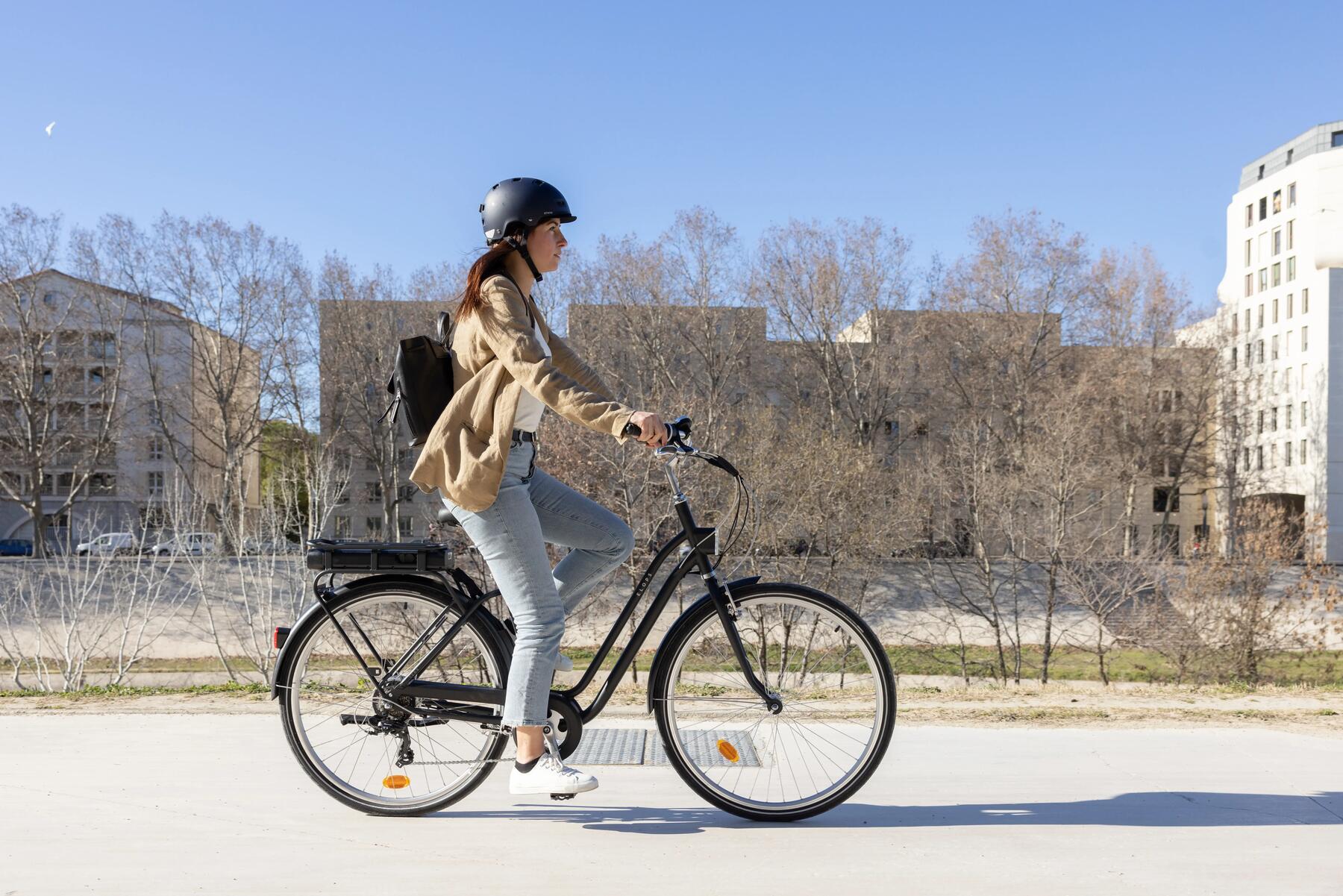Kobieta jadąca na rowerze miejskim z oponami dętkowymi