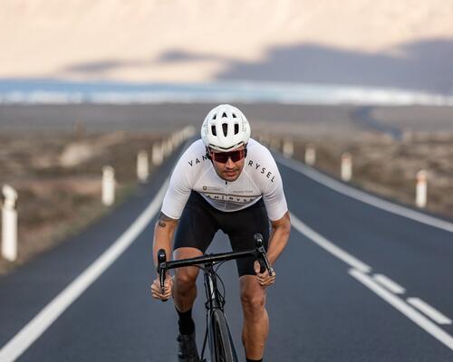 Man cycling down a road wearing Van rysel sunglasses