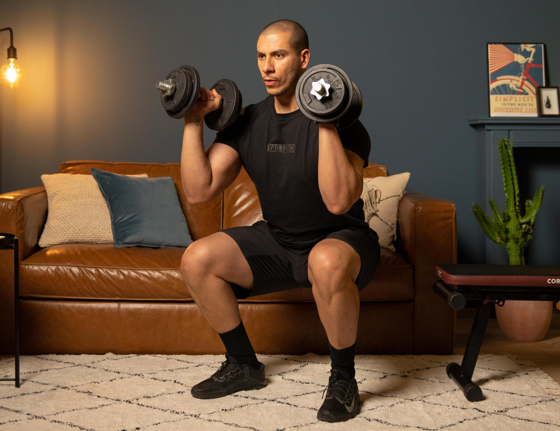 homem a fazer o exercício de agachamento com o par de halteres do kit de 20kg de musculação corength