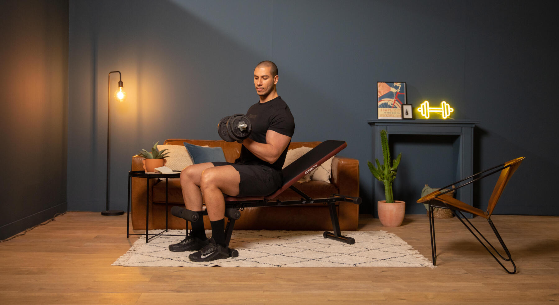 homem a praticar exercício físico com banco 500 corength e kit de 20kg de halteres de rosca corength na sala