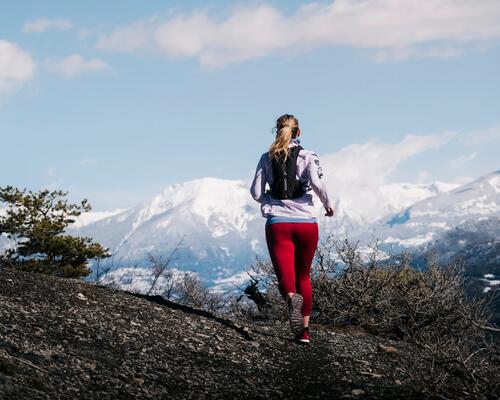 kobieta z plecakiem w legginsach biega w górach