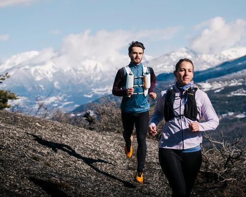 Man and woman running in evadict sportswear in mountains.