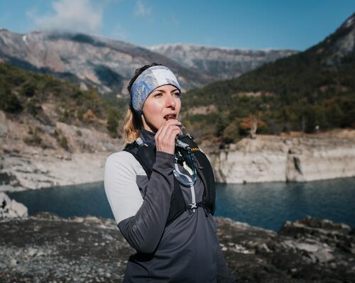 kobieta jedząca baton energetyczny w górach