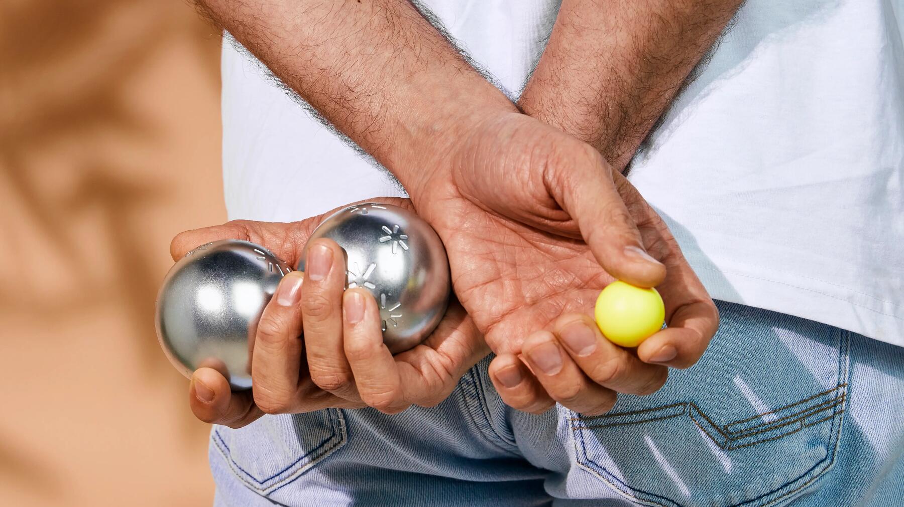 Iemand die petanqueballen vasthoudt
