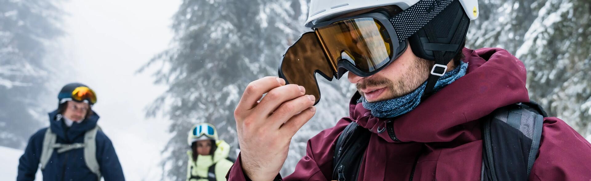 Close-up of man wearing Ski goggles in snowy background.