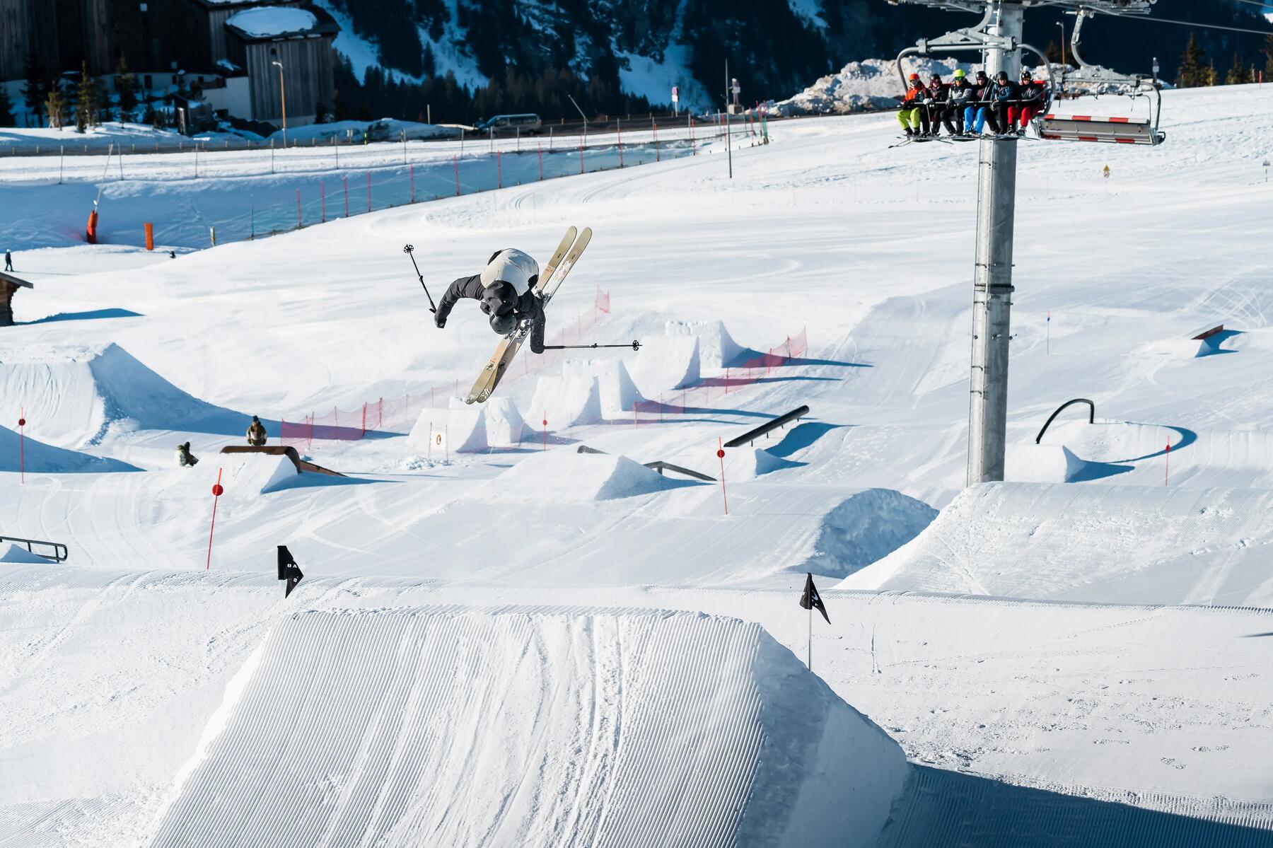 Mężczyzna uprawiający freeskiing z tyłu wyciąg krzesełkowy
