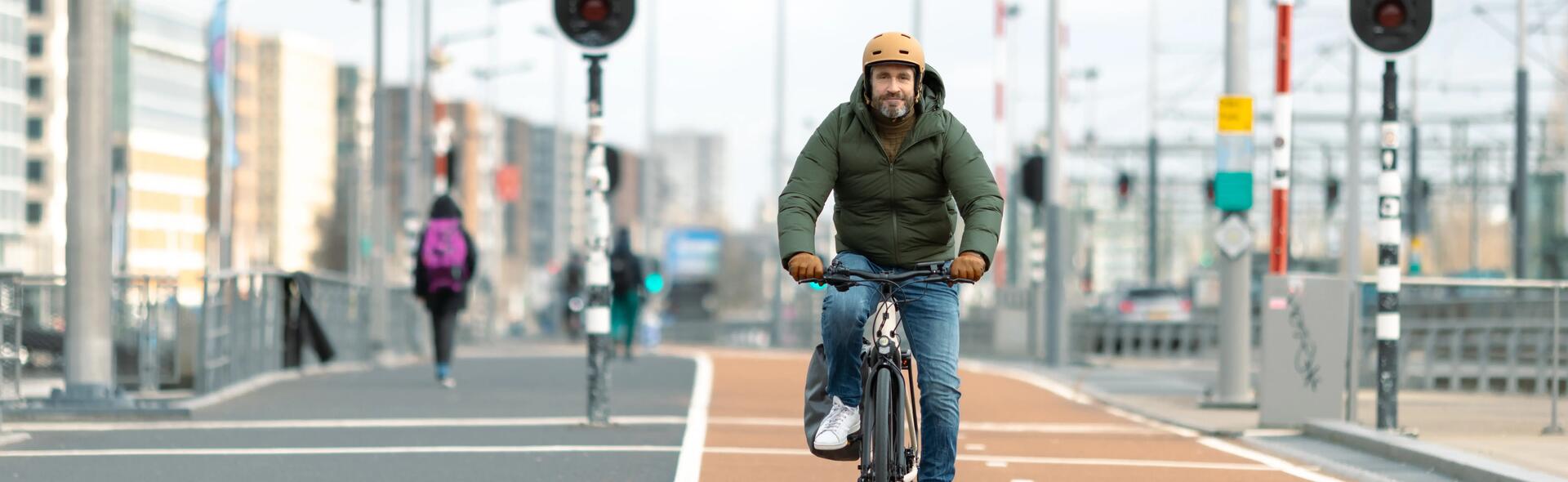 jeune homme qui s'essaye au vélo en ville tout en portant son casque
