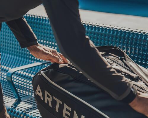 mężczyzna otwierający torbę do sportów rakietowych