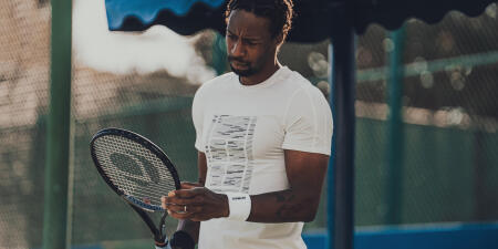 un joueur de tennis observe sa raquette de tennis