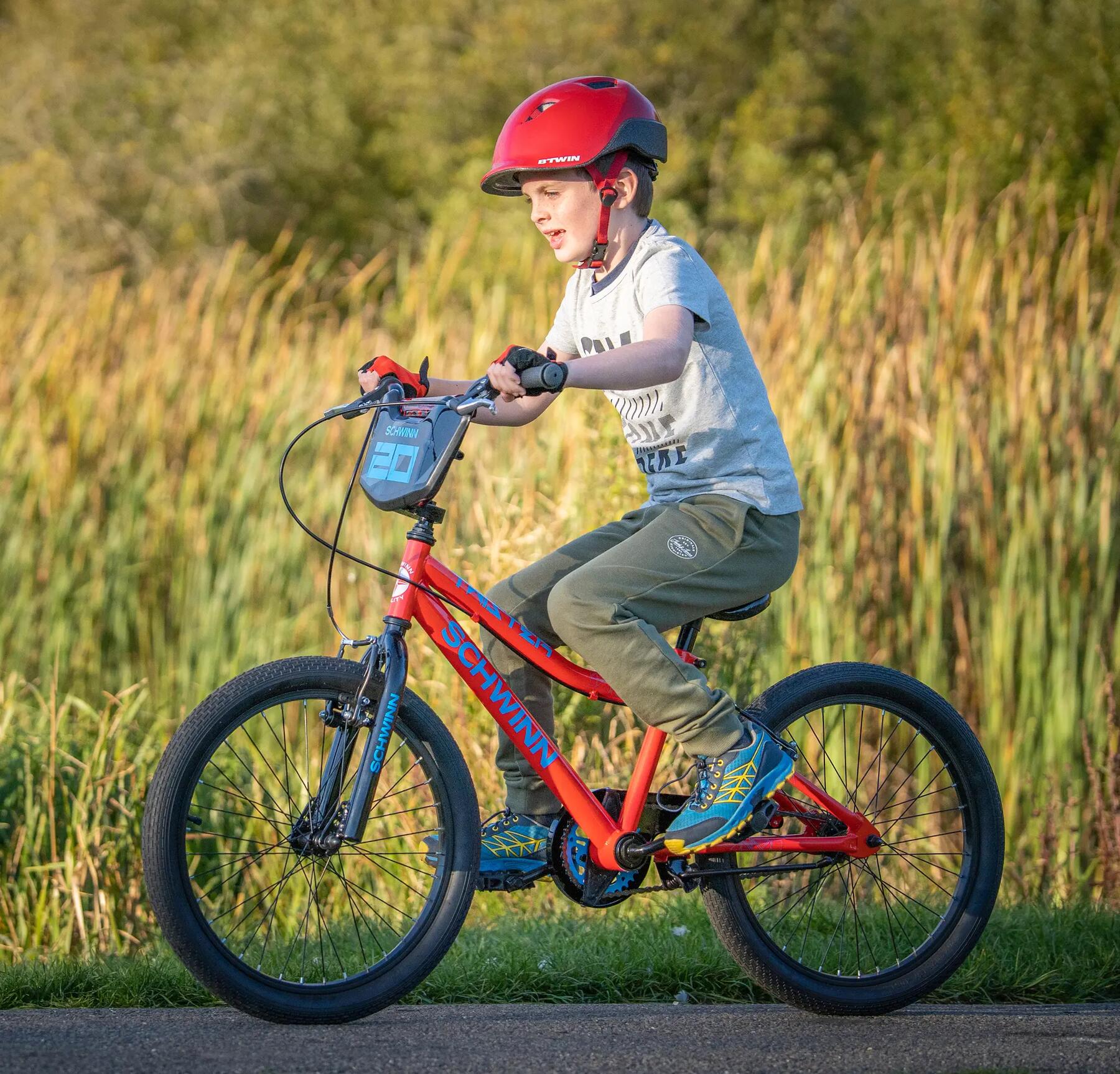 chłopiec w kasku i rękawiczkach rowerowych jadący na rowerze