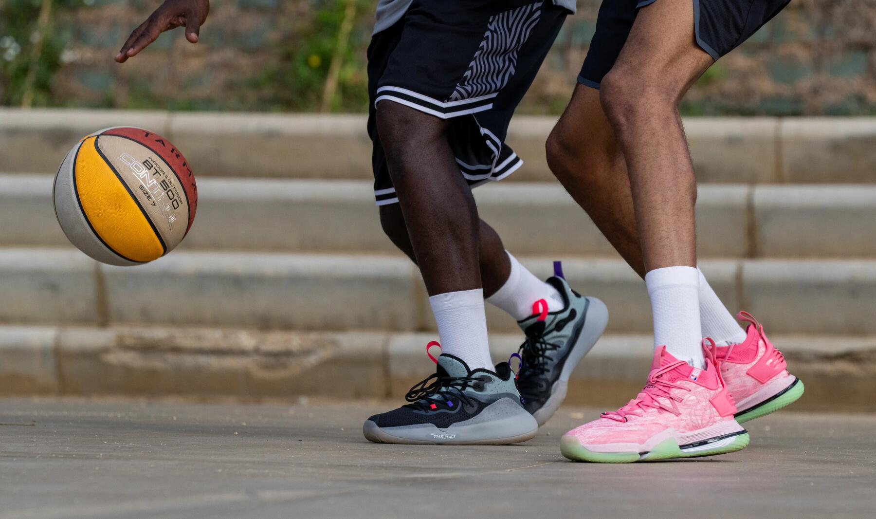 A close up of basketball shoes worn by two men playing basketball