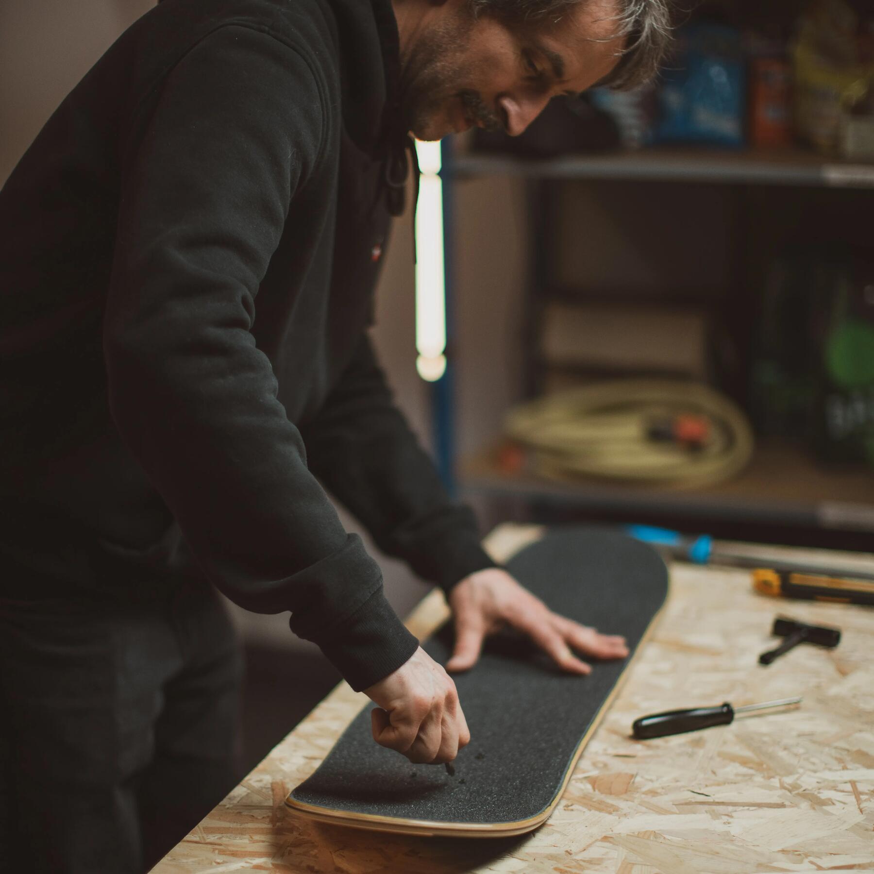 hombre haciendo agujeros a un grip de skate