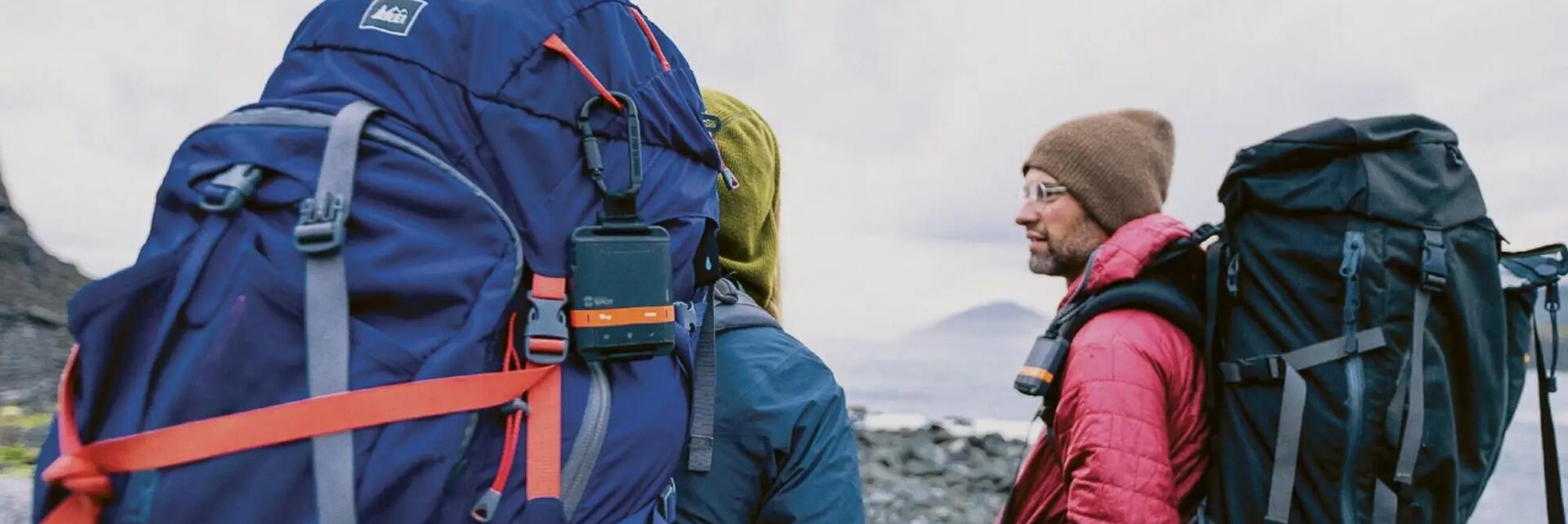 Wanderer mit Rucksäcken auf einer EarthCache-Tour durch eine beeindruckende Naturkulisse