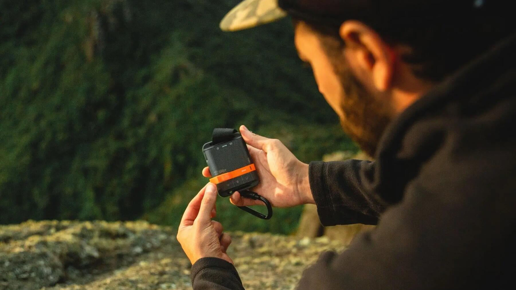 Ein Geocacher hält ein GPS-Gerät in der Hand, um die Koordinaten eines EarthCaches zu finden