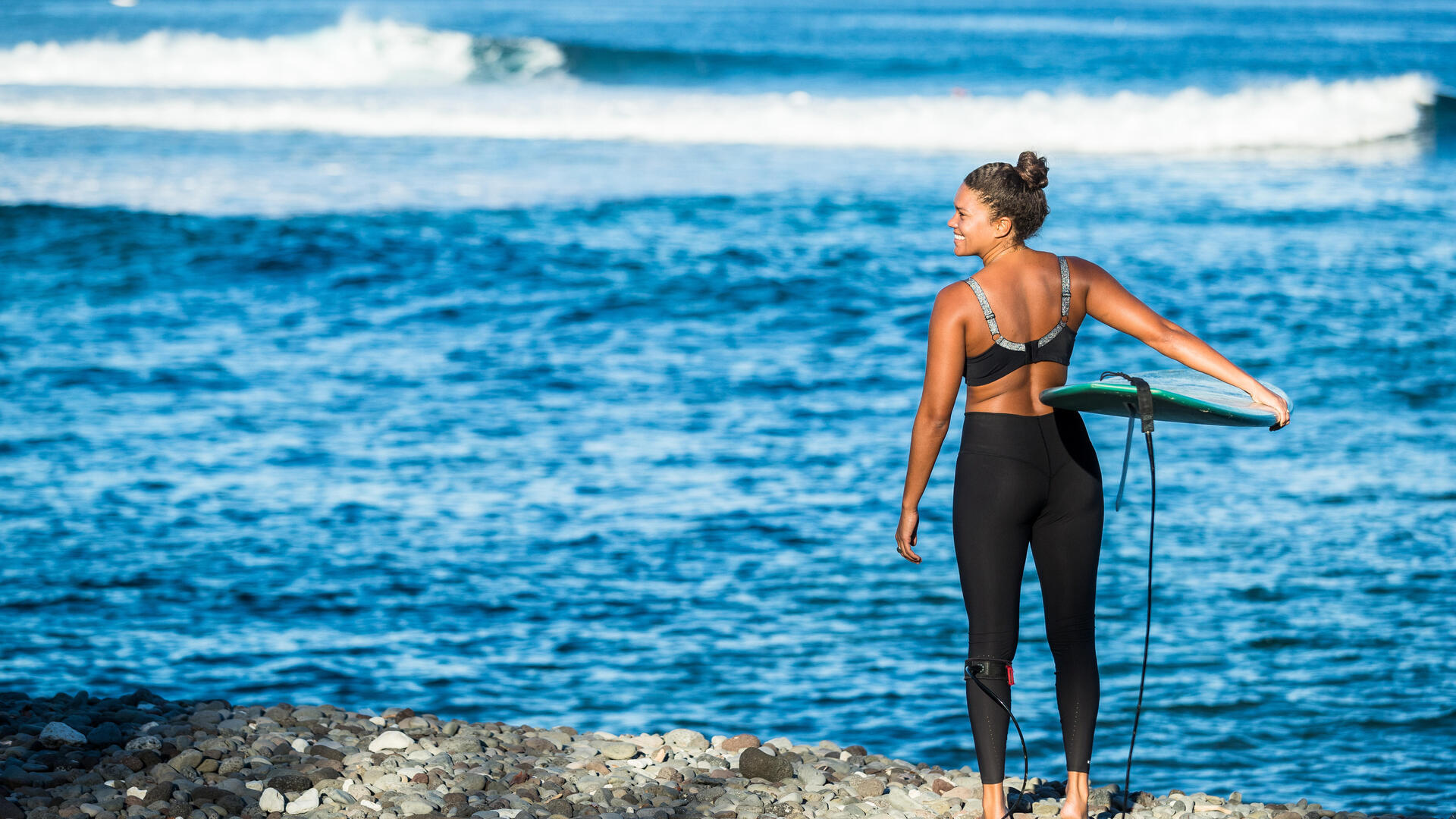 femme sur le bord de l'eau avec sa planche de surf