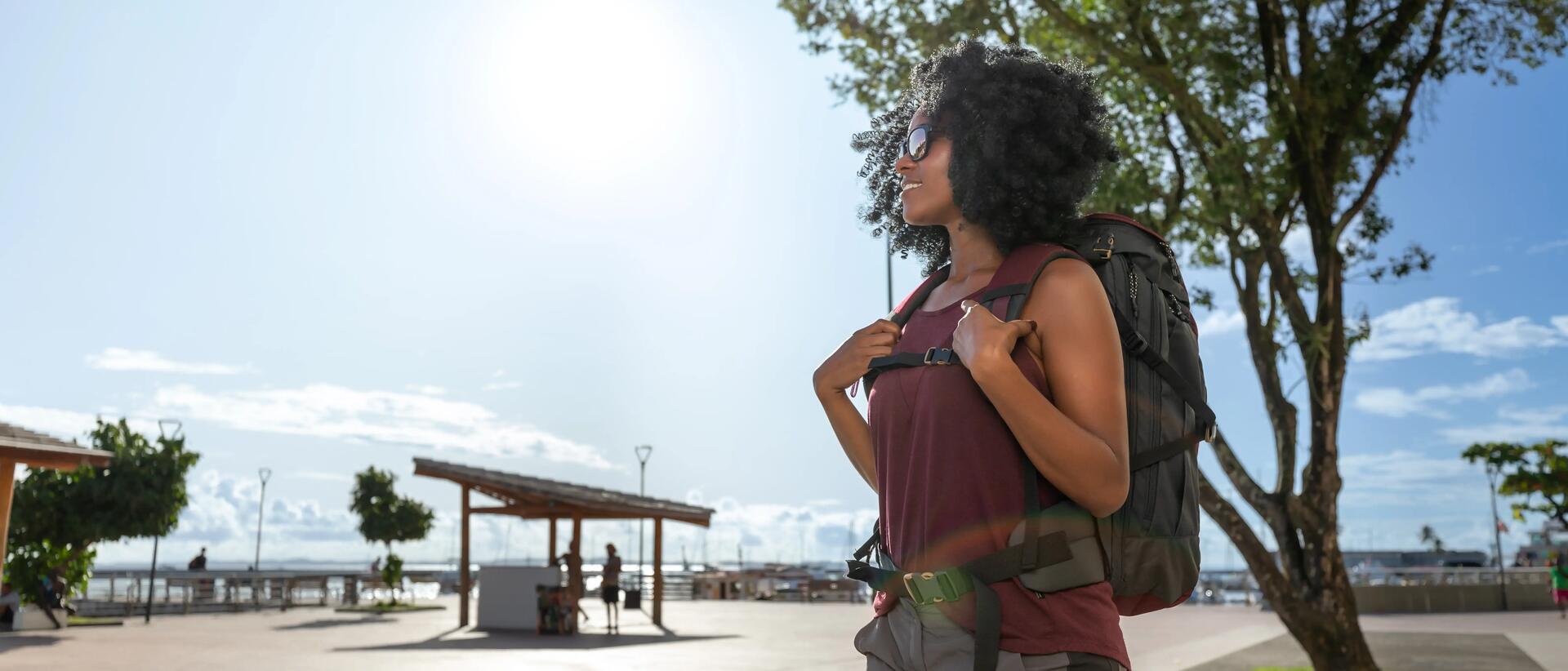 Woman standing outside on a sunny day, wearing sunglasses