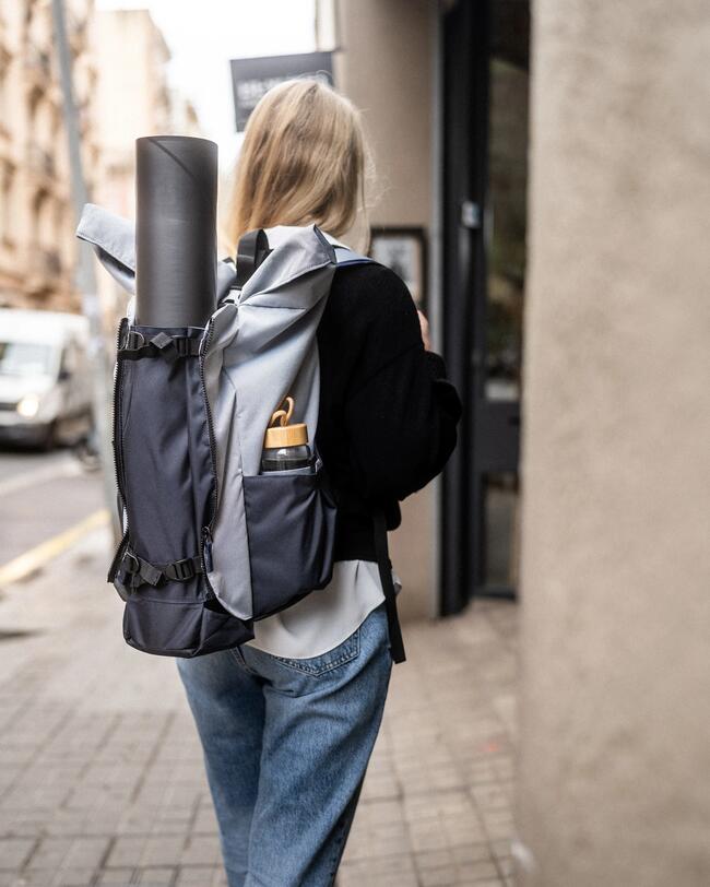 Eine Frau trägt in der Stadt eine Yogatasche.