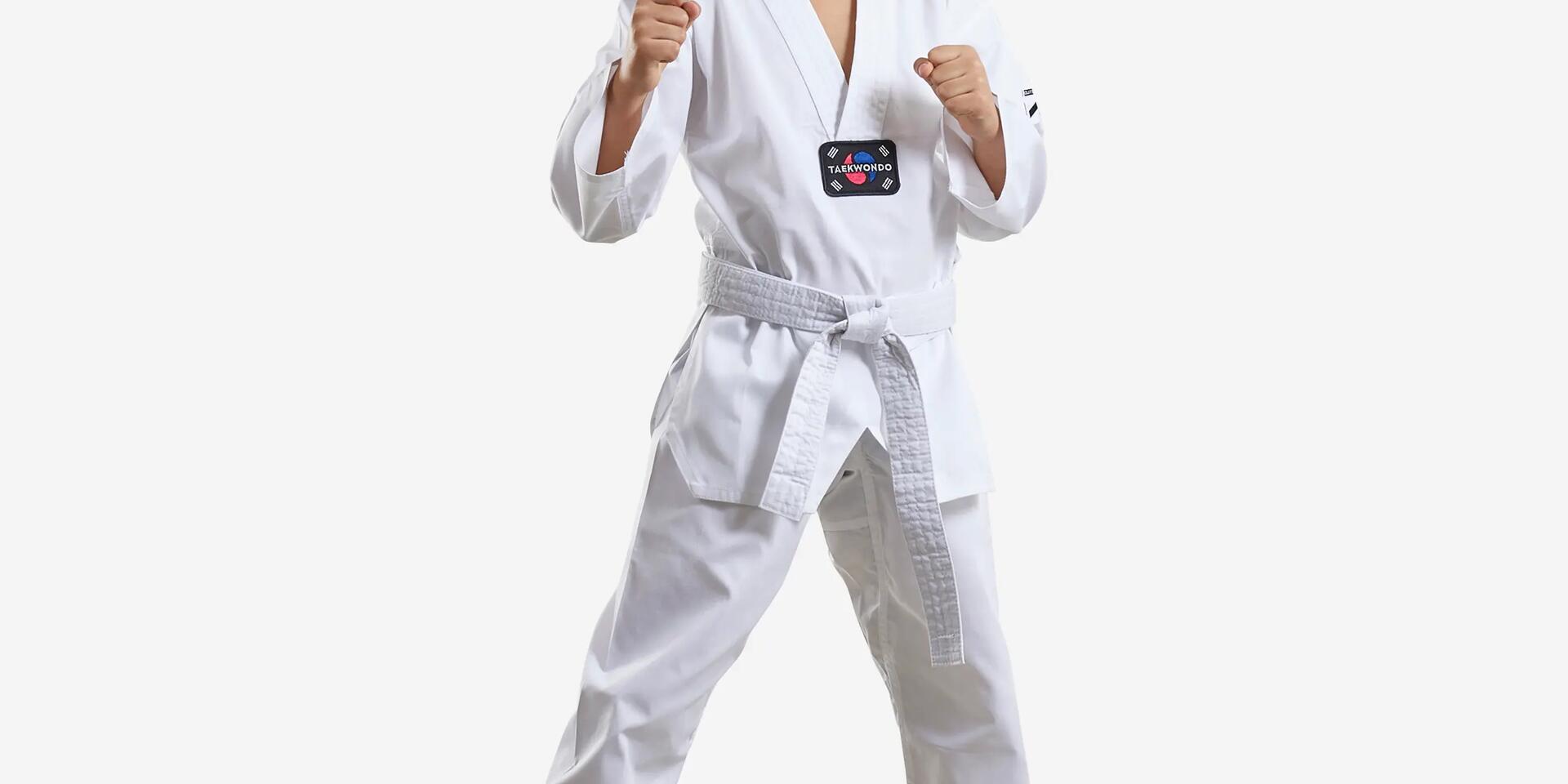 chłopiec stojący w stroju do taekwondo z białym pasem