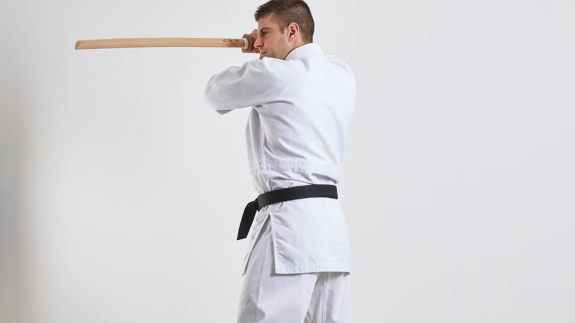 Mężczyzna w karatedze trenujący aikido trzymający w ręku bokken