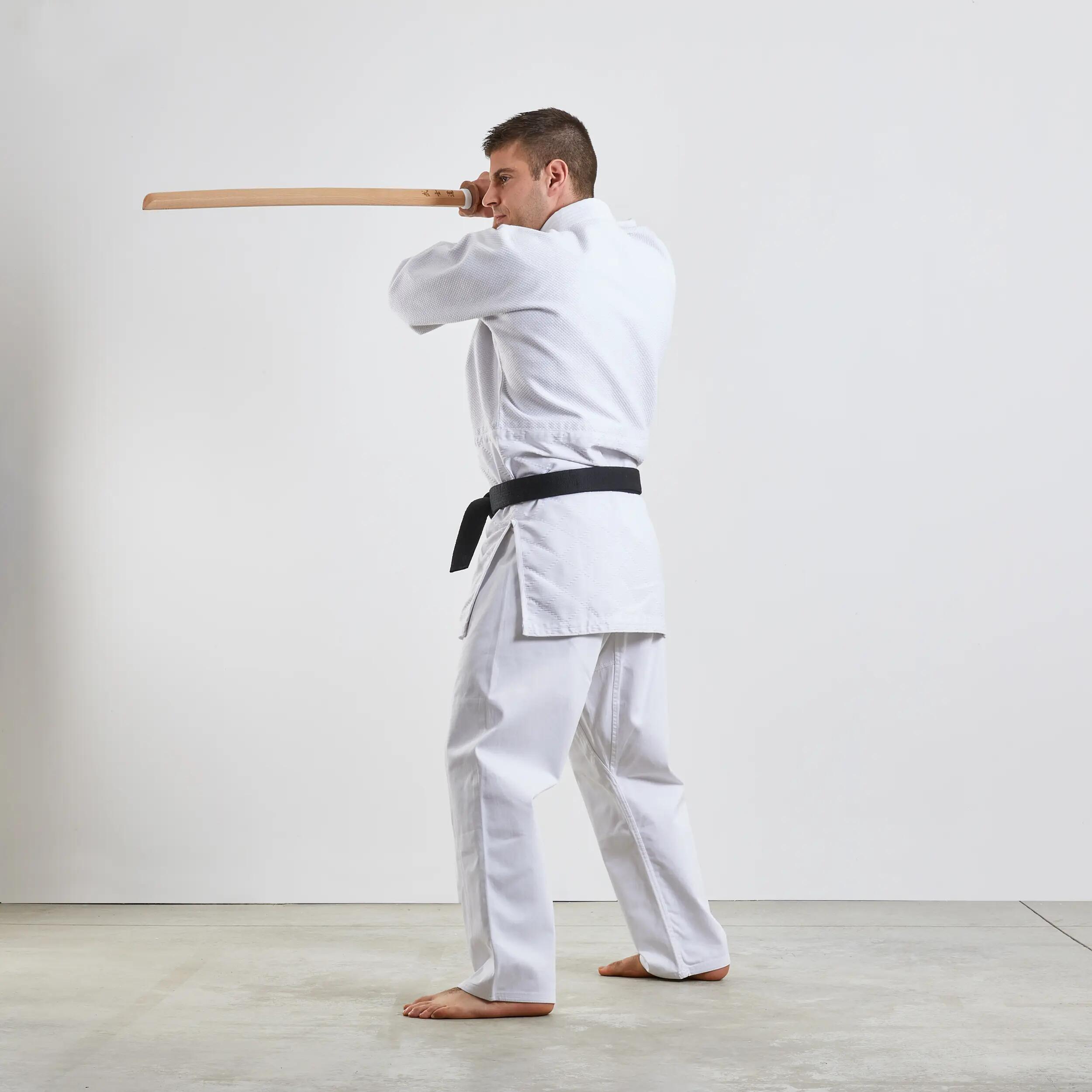 Mężczyzna w karatedze trenujący aikido trzymający w ręku bokken