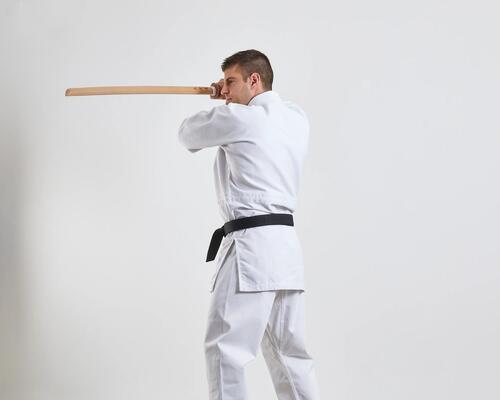 Mężczyzna w karatedze trenujący aikido trzymający w ręku bokken