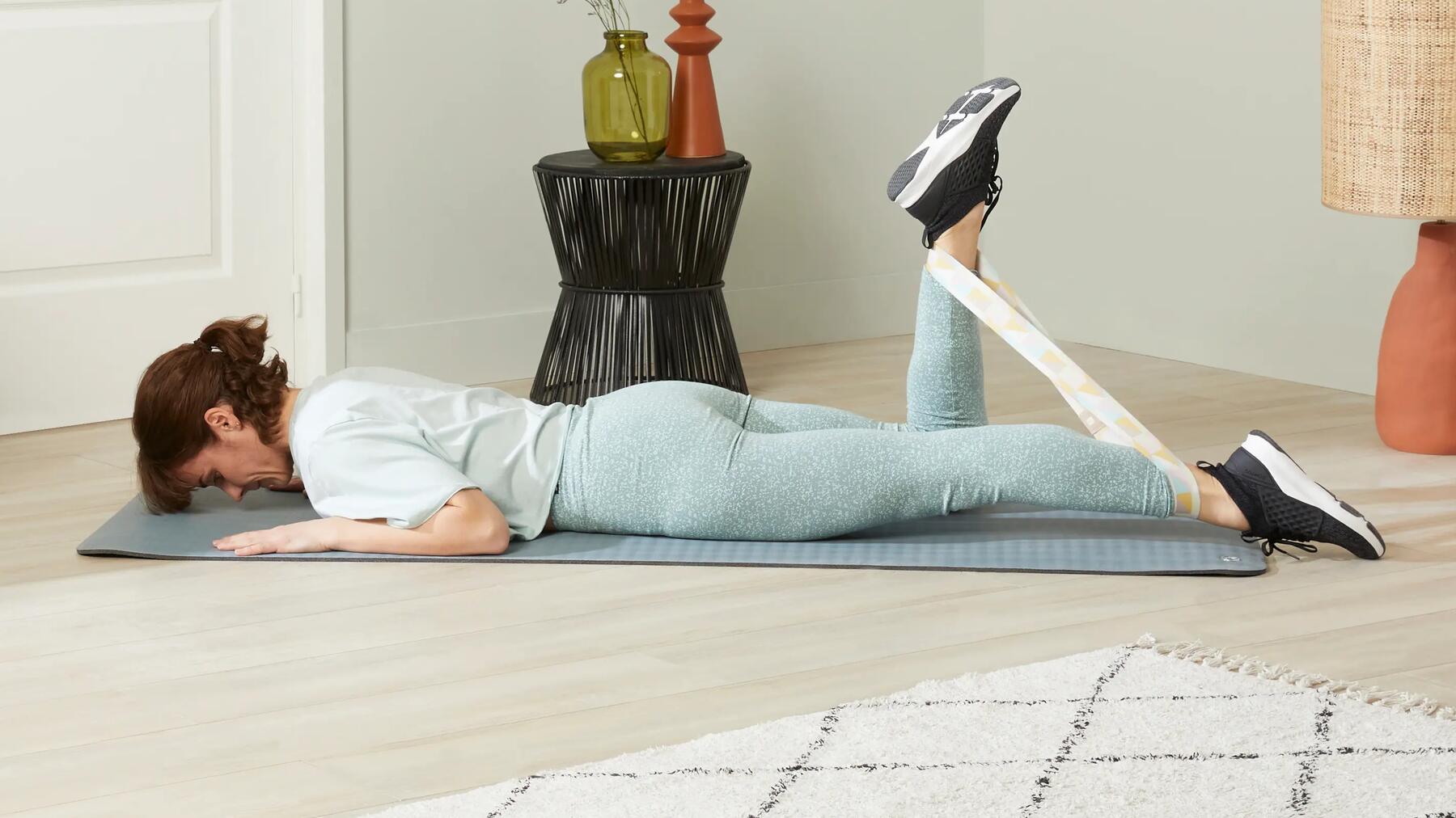 Im Liegen mit einem Fitnessband den vorderen Oberschenkelmuskel dehnen
