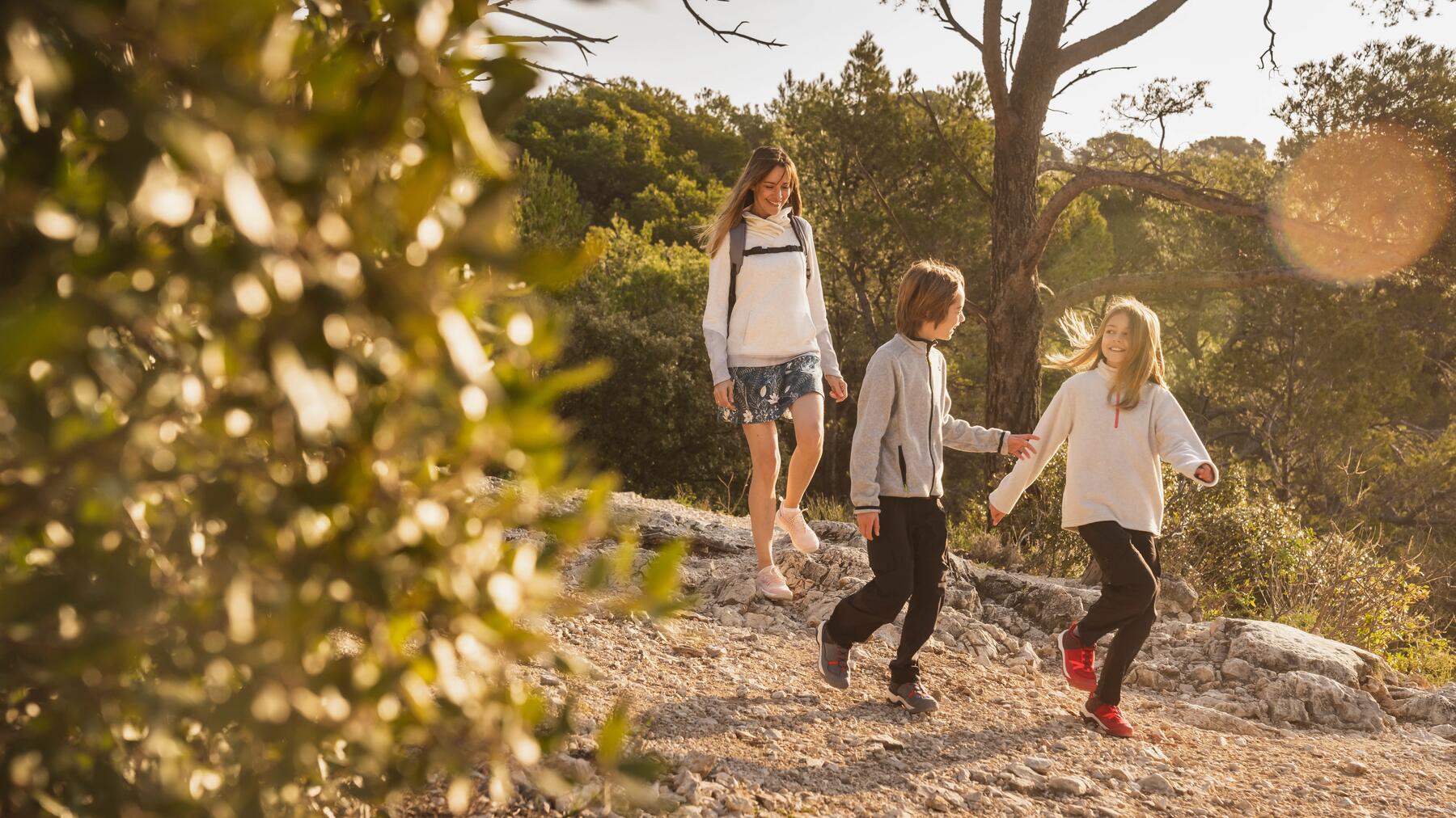 Familie mit Rucksäcken läuft gut gelaunt auf einem naturnahen Pfad des Rothaarsteigs