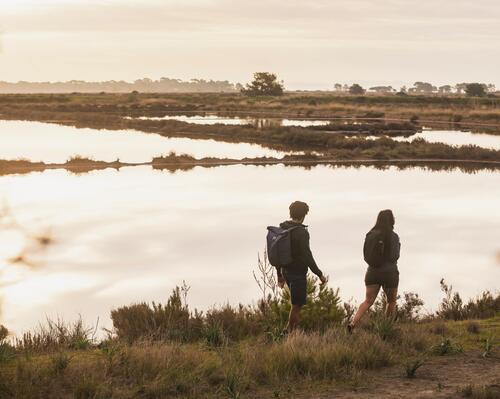 Casal a caminhar junto a uma lagoa